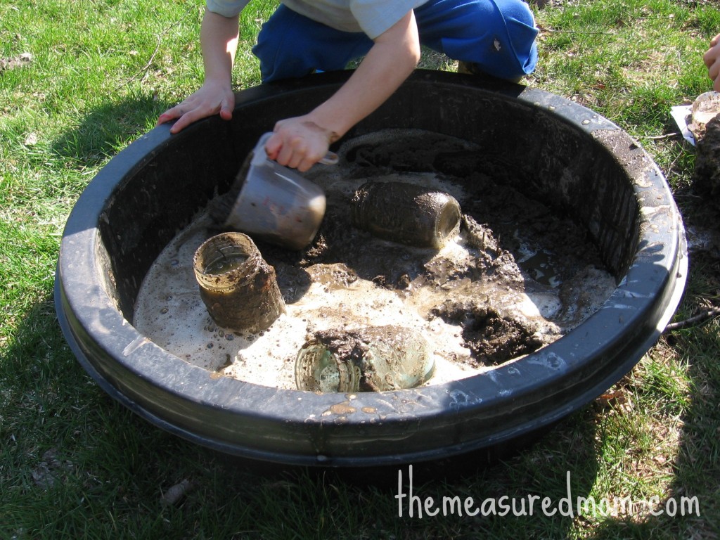 child scooping out mud
