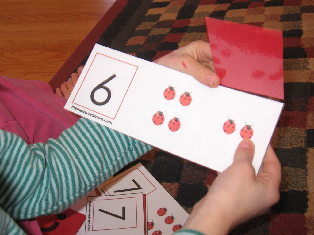 child holding counting ladybug card