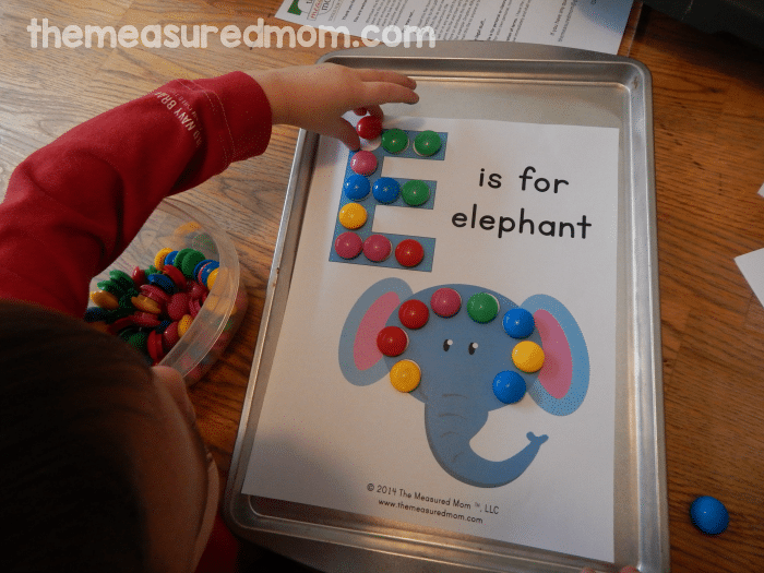 child placing magnets on worksheet