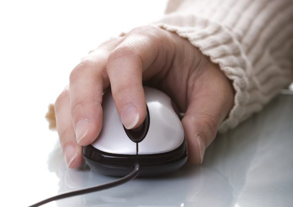 Woman hand on a mouse isolated on white with reflection and copyspace (selective ans soft focus)