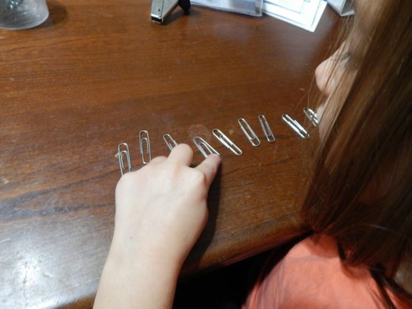 child counting paper clips